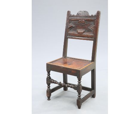 A 17TH CENTURY OAK PANEL-BACK CHAIR, with boarded seat and barleytwist rail to the fore legs. Height of back 107cm