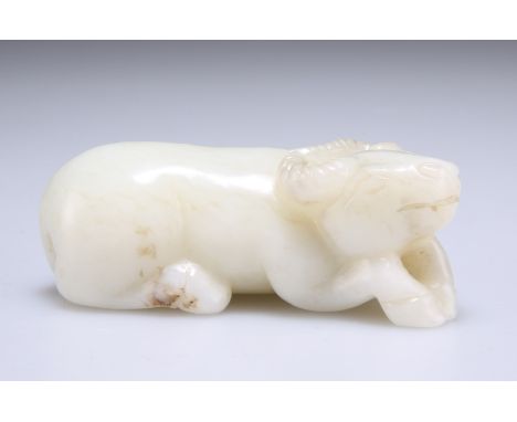 A CHINESE CELADON JADE CARVING OF A BUFFALO, carved recumbent. 7.5cm wide