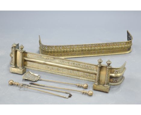 TWO LATE VICTORIAN PIERCED BRASS FENDERS, together with A SET OF THREE HEAVY BRASS FIRE TOOLS. (5), largest fender 123cm long