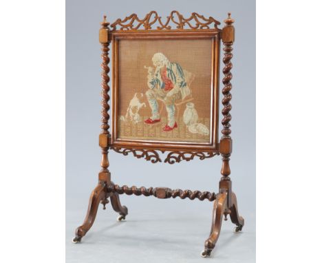 A VICTORIAN ROSEWOOD AND NEEDLEWORK FIRESCREEN,&nbsp;with barley-twist supports and fretwork crest and apron, moving on casto