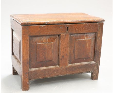 A VERY SMALL 17TH CENTURY OAK COFFER, the moulded rectangular top above a two panel front and with further panels to the side