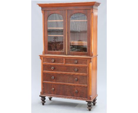 A VICTORIAN MAHOGANY BOOKCASE ON CHEST, the moulded projecting cornice above a pair of arched panel glazed doors, the base wi