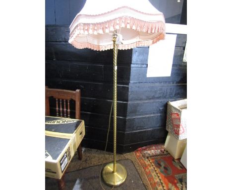 A brass base standard lamp with vintage pink shade