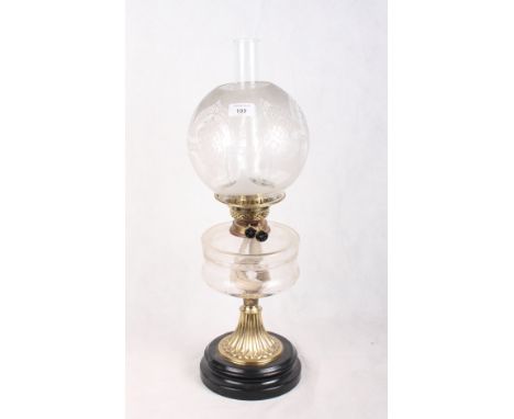 A Victorian oil lamp with spherical etched glass shade, glass reservoir and brass pedestal base, 24" high