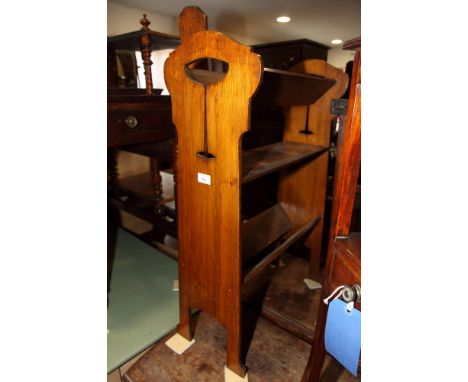 An Arts & Crafts oak two-tier book trough with central shelf