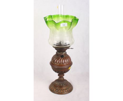 A Victorian oil lamp with etched green edged glass on bronzed pedestal base