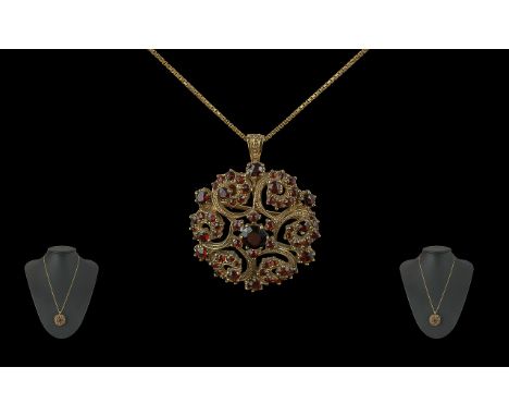 Ladies 9ct Gold Garnet Set Open Worked Pendant / Brooch of Circular Form, Attached to a 9ct Gold Chain. Both Pendant and Chai
