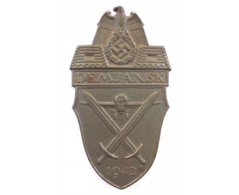 German Third Reich WW2 Army and Waffen SS Demjansk arm  shield. A good scarce grey metal example. Eagle and swastika on ‘DEMJ