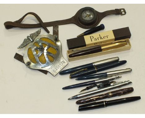 A small compass attached to a leather wrist strap, 4.5cm diameter, an AA car badge 0255578, five various fountain pens, (a/f)