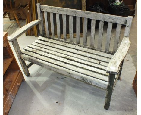 A weathered teak slatted garden bench, 127cm wide.
