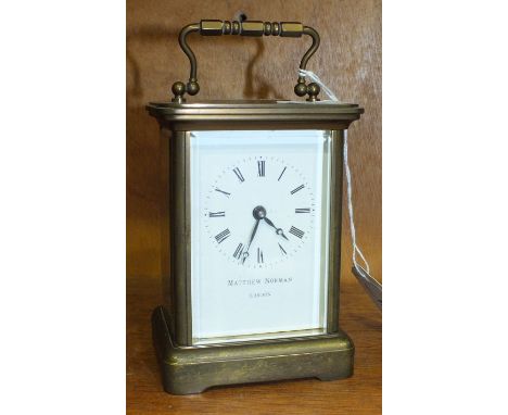 A brass carriage clock, the dial with Roman numerals, marked 'Matthew Norman, London', 14.5cm overall.