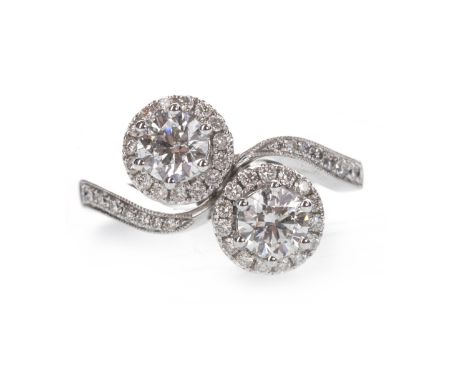 DIAMOND TWIST RING, set with two round brilliant cut diamonds totalling approximately 0.91 carats, bordered by smaller round 