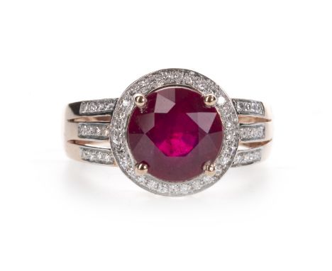 RED GEM SET AND DIAMOND RING, the round red gem within a halo of round brilliant cut diamonds, on trifurcated diamond set sho