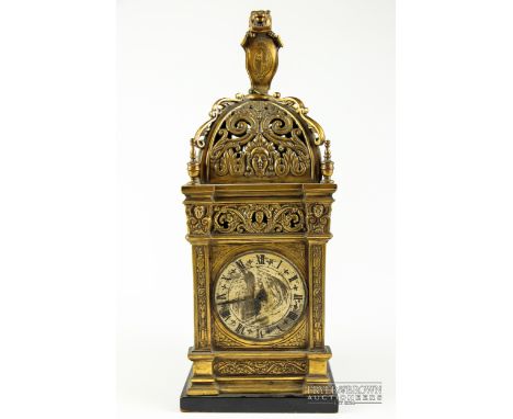 A brass cased clock, pierced scrolling detail, with rampant lion finial 