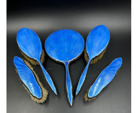 A blue enamel backed dressing table set to include brushes and a mirror 