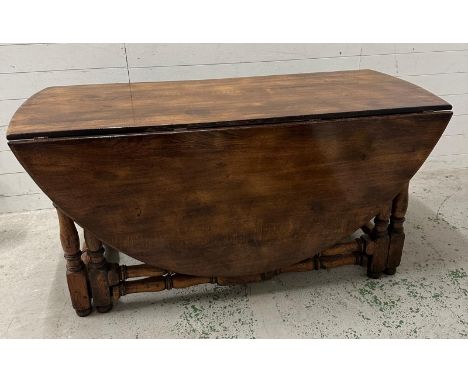A substantial mahogany gate leg wake table with turned legs and stretchers (H74cm W183cm D150cm)