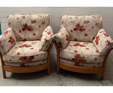 A pair of light Ercol arm chairs upholstered in a floral linen 