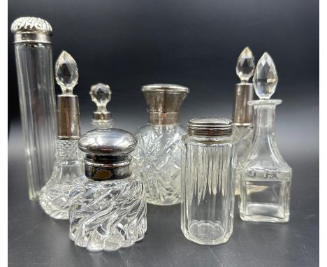 A selection of seven silver topped or capped cut glass scent bottles or dressing table bottles. Various makers and hallmarks