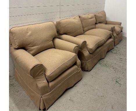 A three seater sofa and two matching arm chairs upholstered in a beige fabric 