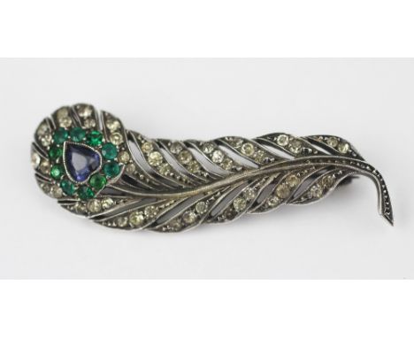 A French paste set peacock feather brooch, set with blue, green and colourless stones in white metal, unmarked, 4.7cm long