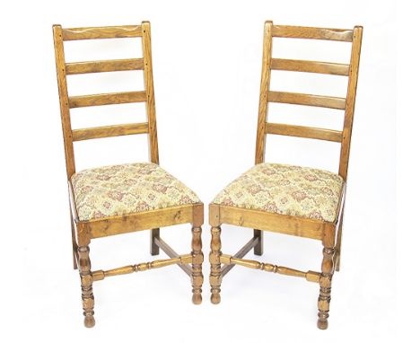 A set of eight golden oak dining chairs by Theo Davies of Glyn Ceriog, with ladder backs and upholstered seats, on turned leg