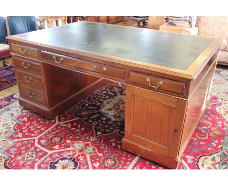 A Victorian mahogany partners desk, with leather inset top above an arrangement of twelve drawers and two cupboard doors, on 