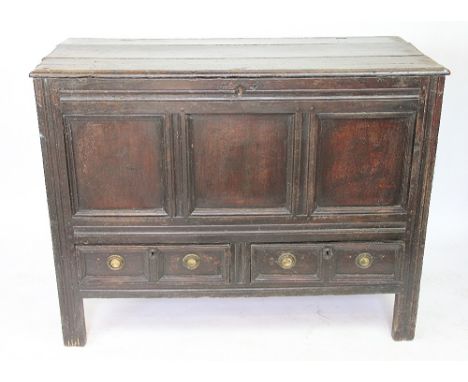 An early 18th century oak mule chest, with hinged top, triple panelled front and two drawers, on stile feet, 91cm H x 107.5cm