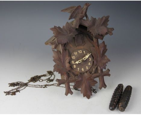 A 19th century Black forest cuckoo clock, with moulded leaf decoration and surmount, pendulum and weight, 27cm high