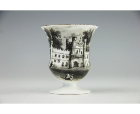 An early 19th century egg cup, transfer printed in black with a scene of a gate house or castle, unmarked, 6.5cm