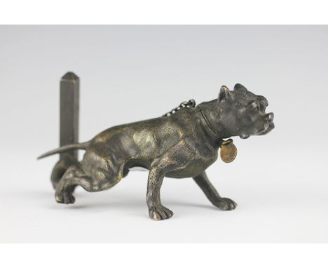 An Austrian bronze vesta and striker in the manner of Franz Bergmann, 19th century, designed as a tethered dog, the head hing