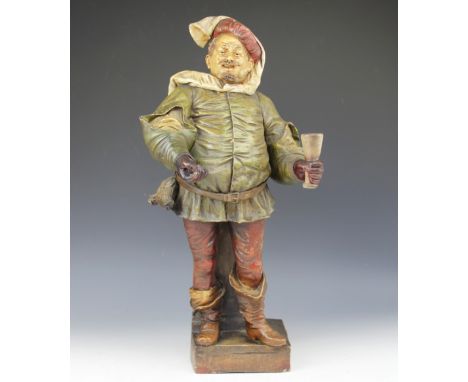 A 19th century Goldscheider terracotta figure of a cavalier, modelled with ale mug and leaning against a column, model number