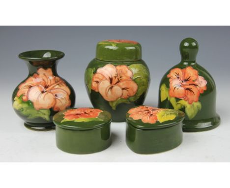 A collection of Moorcroft Hibiscus pattern wares, each decorated with peach blooms against a green ground, to include; a ging