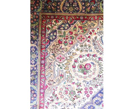 A Persian Tabriz wool carpet, worked with a scrolling foliate design against an ivory ground, 283cm x 196cm 