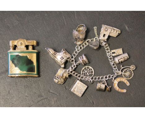 SILVER CHARM BRACELET & LIGHTER - a silver charm bracelet marked James Swann and Son 1947 featuring 12 charms (cottage with m