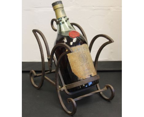 COGNAC - MARTELL - a bottle of Martell Medaillon Fine Champagne Cognac Fondee en 1715 on a vintage Martell iron bottle stand.