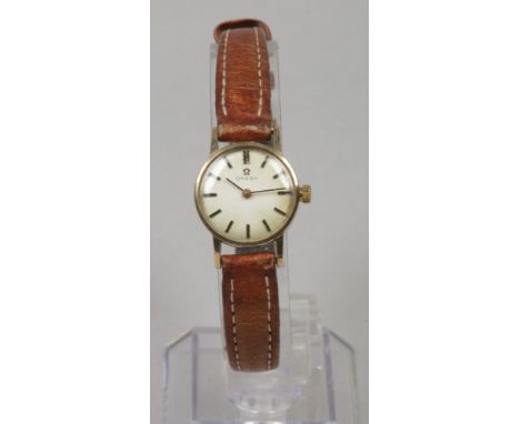 A ladies 9ct gold manual Omega wristwatch with satin dial and applied baton markers.