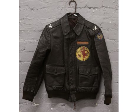 A World War II style reproduction USA Airforce leather flight jacket with squadron patch metal insignia and painted American 