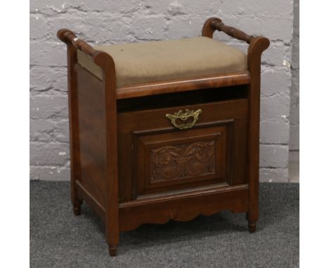 An Edwardian carved mahogany piano stool.