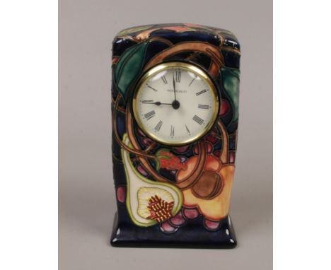A Moorcroft mantel clock decorated in the Queens Choice pattern.