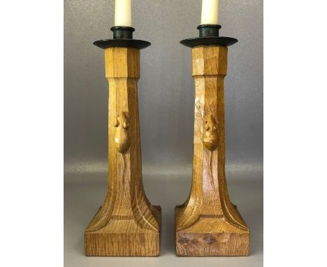 Pair of Robert 'Mouseman' Thompson oak candlesticks with iron sconces, of octagonal column form on square bases, with carved 