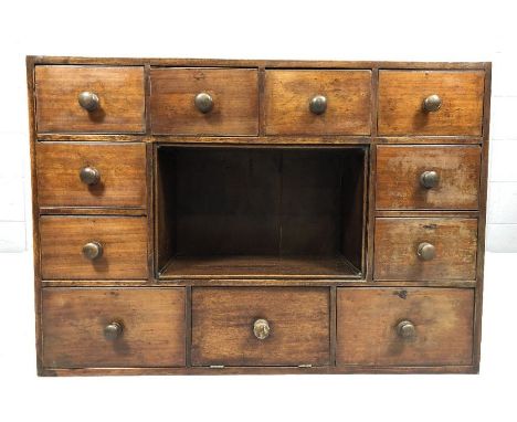 Antique pine set of eleven drawers with central aperture / shelf and turned handles, believed to have been a gardeners seed c