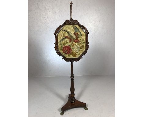 Turned Victorian pole screen on brass lion paw feet with carved frame and tapestry depicting a parrot and roses, approx 140cm