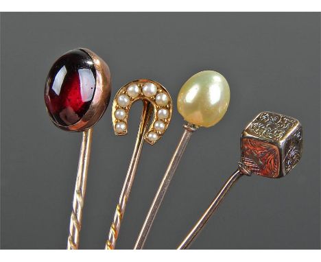 Four stick pins, to include a garnet set example, a 15 carat gold horse shoe example, a pearl example and a cube example, (4)