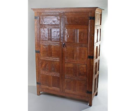 1930's Robert ``Mouseman`` Thompson panelled oak wardrobe, with a concave cornice top above two doors opening to reveal a rai