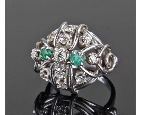 White metal diamond and emerald set ring, the banded domed ring with eleven brilliant cut diamond and two emeralds, ring size