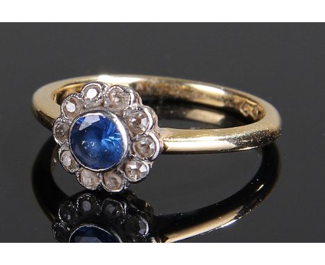 18 carat gold diamond and sapphire ring, the central sapphire surrounded with old cut diamonds, to form a flower head, ring s