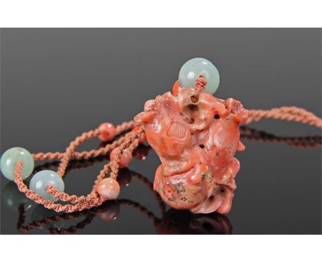 19th Century Chinese coral and jade necklace, the coral pendant carved to form lotus flowers attached to a cord with jade and