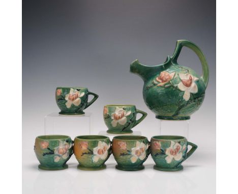 This 7-piece set from Roseville Pottery features the Magnolia pattern in a striking green glaze, including a large pitcher (m