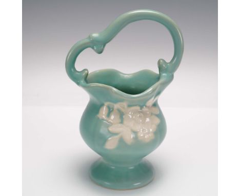 This charming Weller Pottery basket vase features a flowing Art Nouveau form with a scalloped rim and gracefully arched handl