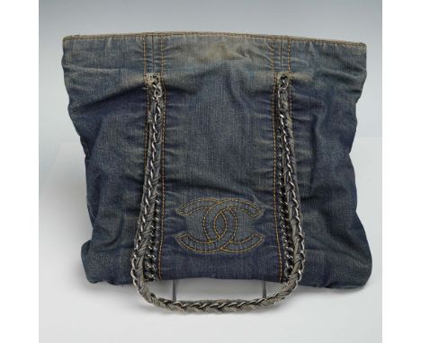 Chanel designer shoulder tote crafted in distressed dark denim with signature chain and leather handles and prominent stitche